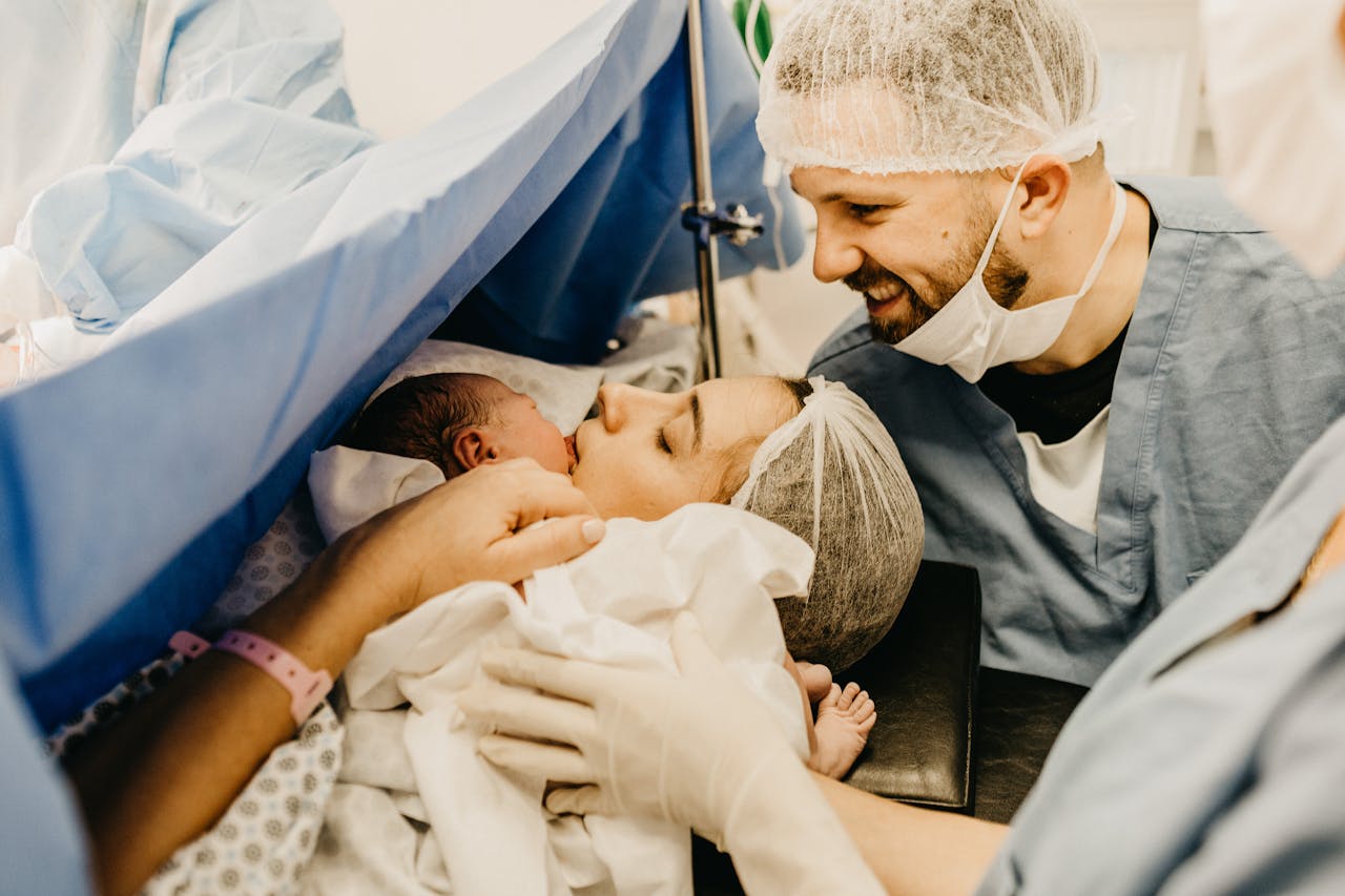 services-02 A cherished family moment as new parents welcome their baby in a hospital delivery room.