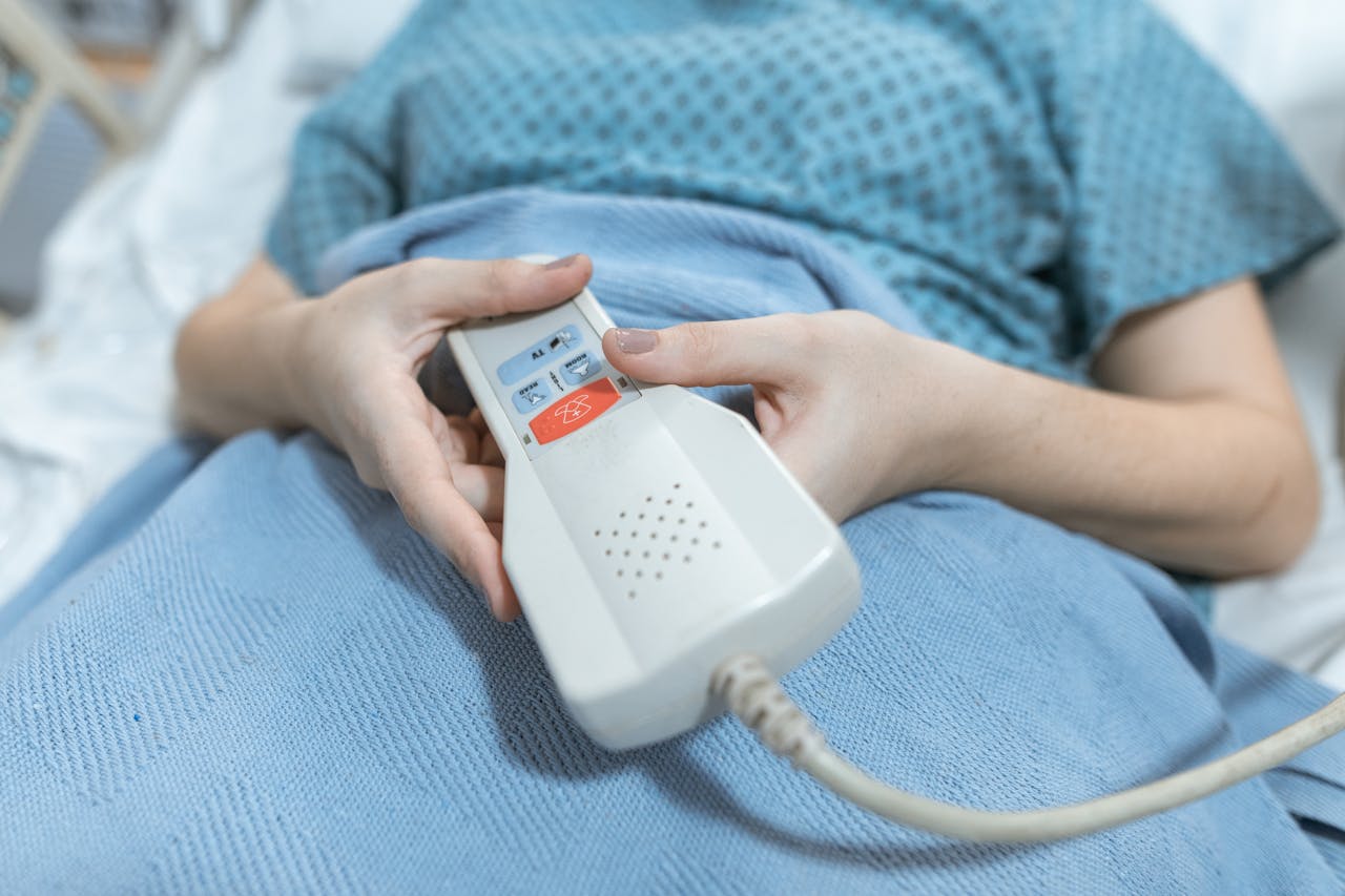 about-us-01 Close-up of a patient's hands holding a remote control in a hospital bed, showing care and medical settings.